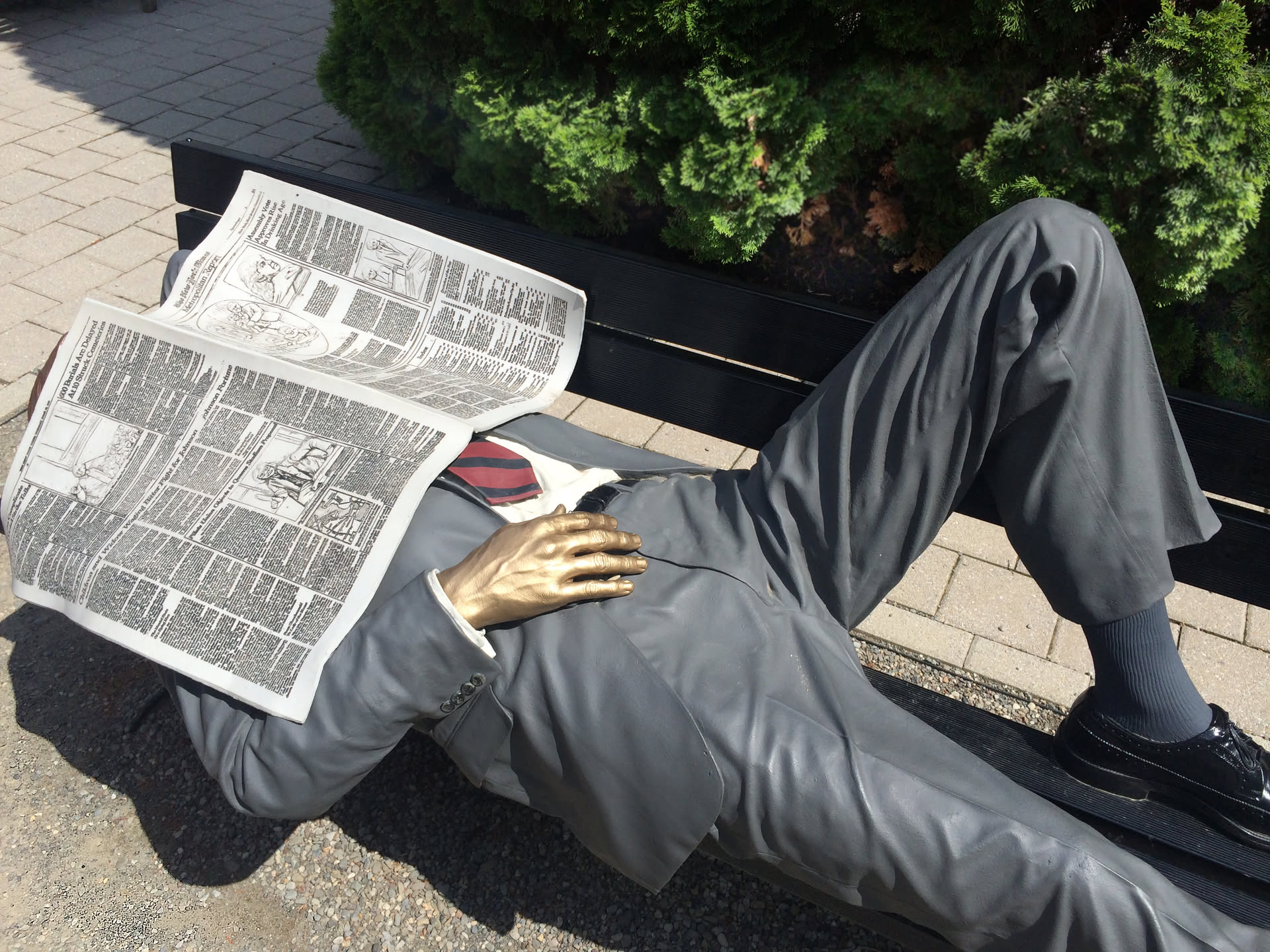 Nature Gallery Preview of a sculpture of a working man sleeping on a bench with a newspaper